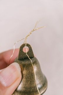 先ほど捻ったところにベルもくくりつけます。