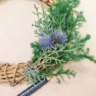 エリンジウムやコットンなど、ポイントになるものはバランスをみながら入れ込み、ワイヤーでぐるぐると巻き付けます。
