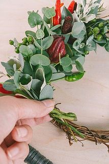 リース台に花材を沿わせながらワイヤーを巻き付けます