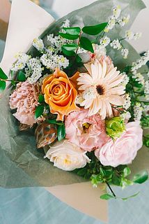 お花の内容はおまかせですが、オレンジ、ピンクのバラ、トルコキキョウ、ガーベラなど明るいカラーリングのブーケをお届けします。